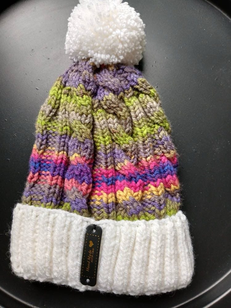 Cable-knit bobble hat striped lime, violet, taupe and pink, with a white cuff and white bobble
